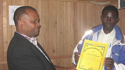 Executive Chairman Muet presenting the certificate to Vitus Mponzi